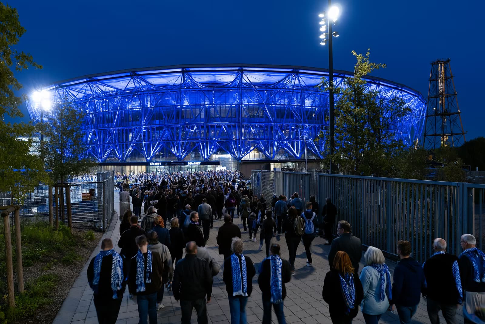 Fotbalový stadion v Porúří v noci září královskou modří, když se fanoušci v šálách hrnou k branám po přestupu Gosense do Schalke.