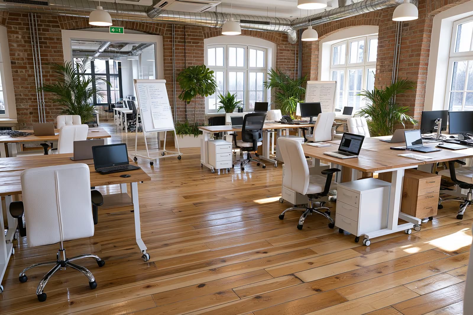 Zakladatelé pracující společně u stolů v moderní německé kanceláři startupu.